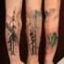 Colored abstract style forearm tattoo of dark forest and trees