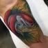 Colored biceps tattoo of creepy bird