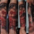 Colored forearm tattoo of creepy woman face with key