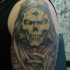 Colored interesting looking illustrative style shoulder tattoo of creepy Grimm reaper