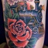Treno a vapore colorato vecchio stile scuola con grande tatuaggio rosa rossa sul braccio