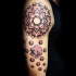 Colored shoulder tattoo of large ornamental flower with geometrical figure