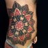 Colored stippling style side tattoo of big flower