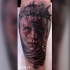 Colored terrifying looking tattoo of woman face with vine
