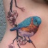 Tatuaje en el costado, pájaro realista en la rama