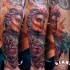 Colorful illustrative style forearm tattoo of bloody woman with heart