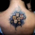 Colorful illustrative style upper back tattoo of cute owl on tree