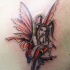 Tatuaje en el hombro,
hada en vestido rojo llamativo