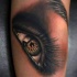 Tatuaje en el brazo de un ojo de mujer en color.