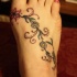 fiore di vite colorato tatuaggio sul piede