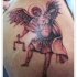 Tatuaje  de arcángel con balanza en el brazo