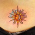 Tatuaje de luna y sol brillante en la espalda baja