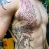 Tatuaje en el costado, estatua de justicia con alas espada y balanza