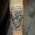Tatuaje en el antebrazo, corazón en el mapa