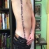 Tatuaje en el costado,
inscripción vertical en hebreo
