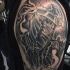 Creepy looking black and white Death skeleton tattoo on shoulder combined with dark cemetery