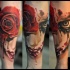 Creepy looking colored forearm tattoo of bloody face with rose