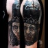 Creepy looking shoulder tattoo of evil monster head with cemetery