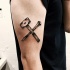Gekreuzte Hammer und Nagel Tattoo am der Schulter im Gravur Stil