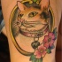 Nette Katze mit Kragen im Rahmen mit rosa Blume Tattoo im Oldschool Stil