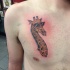 Tatuaje en el pecho, 
cabeza de jirafa en gafas