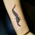 carina inchiostro grigio piuma tatuaggio su braccio