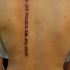 Tatuaje  de inscripción en hebreo  a lo largo de la columna vertebral