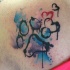 Tatuaje en el hombro, huella de animal y corazones con manchas de varios colores