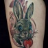 Cute illustrative style thigh tattoo of beautiful rabbit and red apple