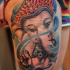Tatuaggio colorato sulla gamba il dio Ganesha