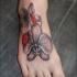 Tatuaggio colorato sul piede le coccinelle & i fiori