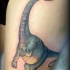 Cute looking illustrative style dinosaur tattoo on thigh