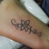 carina semplice inchiostro grigio fiore tatuaggio su piede
