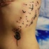 Tatuaggio delicato sul fianco gli uccelli piccoli che volano