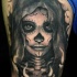 Tatuaje en el brazo, santa muerte chica, colores oscuros
