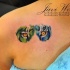 Deep look of tiger's eyes green and blue side colored tattoo on shoulder blade by Javi Wolf