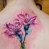 Delicate pink lily flowers tattoo on upper back in watercolor style