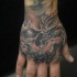 Tatuaje en la mano, cráneo con dientes negros