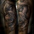 Tatuaje detallado del brazo superior del pulpo con cráneo humano