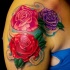Tatuaggio colorato sul deltoide le rose