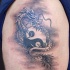 Tatuaggio carino sul deltoide il dragone disegnato in stile Yin-Yang