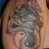 Tatuaggio sul deltoide il dragone disegnato in stile Yin-Yang