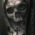 Drammatico dettagliato e dipinto da Eliot Kohek tatuaggio di teschio umano con croci tombali