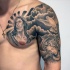 Dramatic looking black and white religious style shoulder and chest tattoo