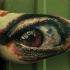 Tatuaje en el brazo de un ojo rojo terrible.