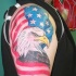 Eagle wrapped in usa flag tattoo on shoulder