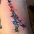 Eiffel Tower with rainbow colored paint drips tattoo on side by Jave Wolf in watercolor style
