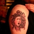 Engraving like black ink shoulder tattoo of small Medusa head