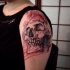 Engraving style big shoulder tattoo of human skull and butterfly