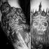Engraving style black and white biceps tattoo of skeleton king with crown